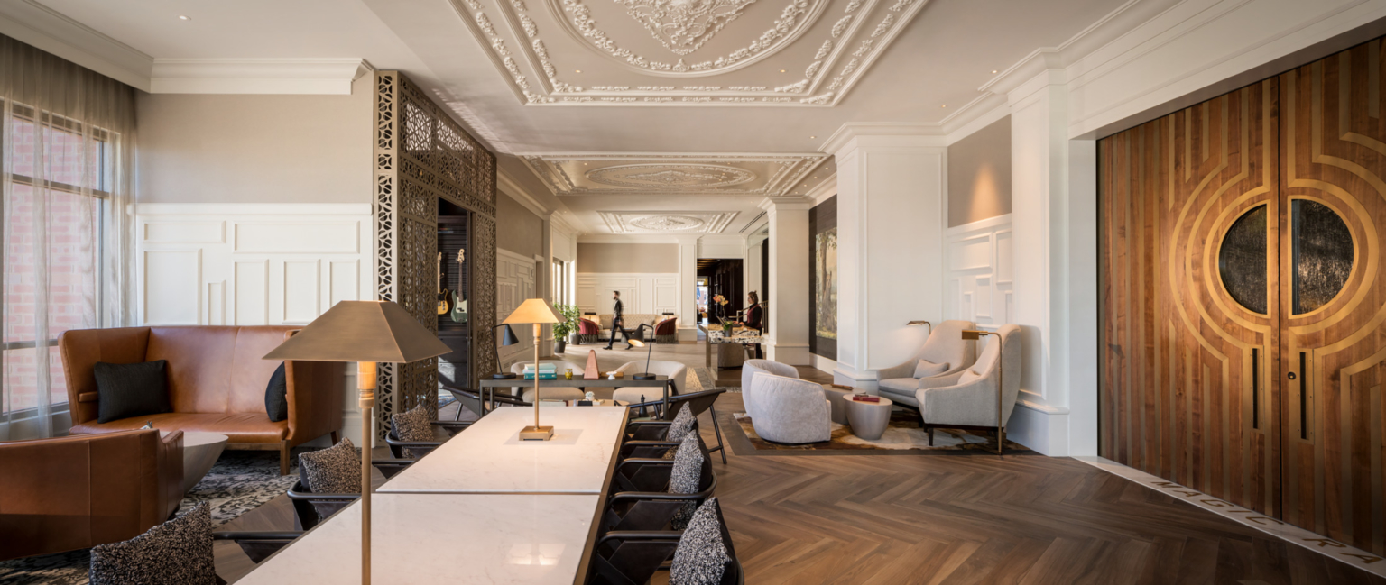 study and work area with long table and tabletop lighting, crown molding on the ceiling, wood double doors at elizabeth hotel