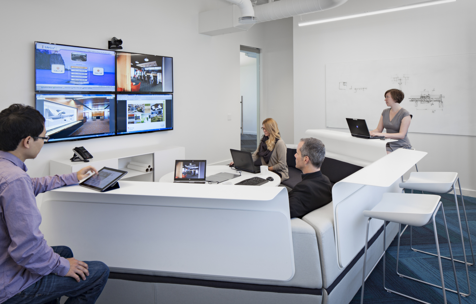 team collaborating with multiple screens, technology, and tiered seating team collaborating with multiple screens, technology, and tiered seating