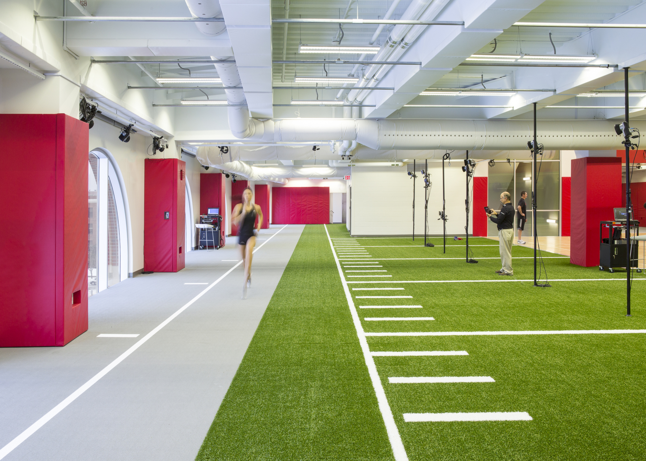 inside university of nebraska athletic performance lab with a runner on the left and green turf on the right inside university of nebraska athletic performance lab with a runner on the left and green turf on the right