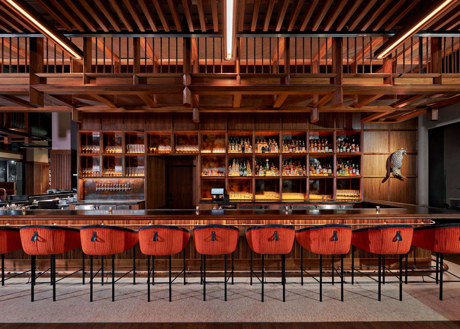 a bar finished with wood and orange and blue upholstery with taxidermy on the wall a bar finished with wood and orange and blue upholstery with taxidermy on the wall