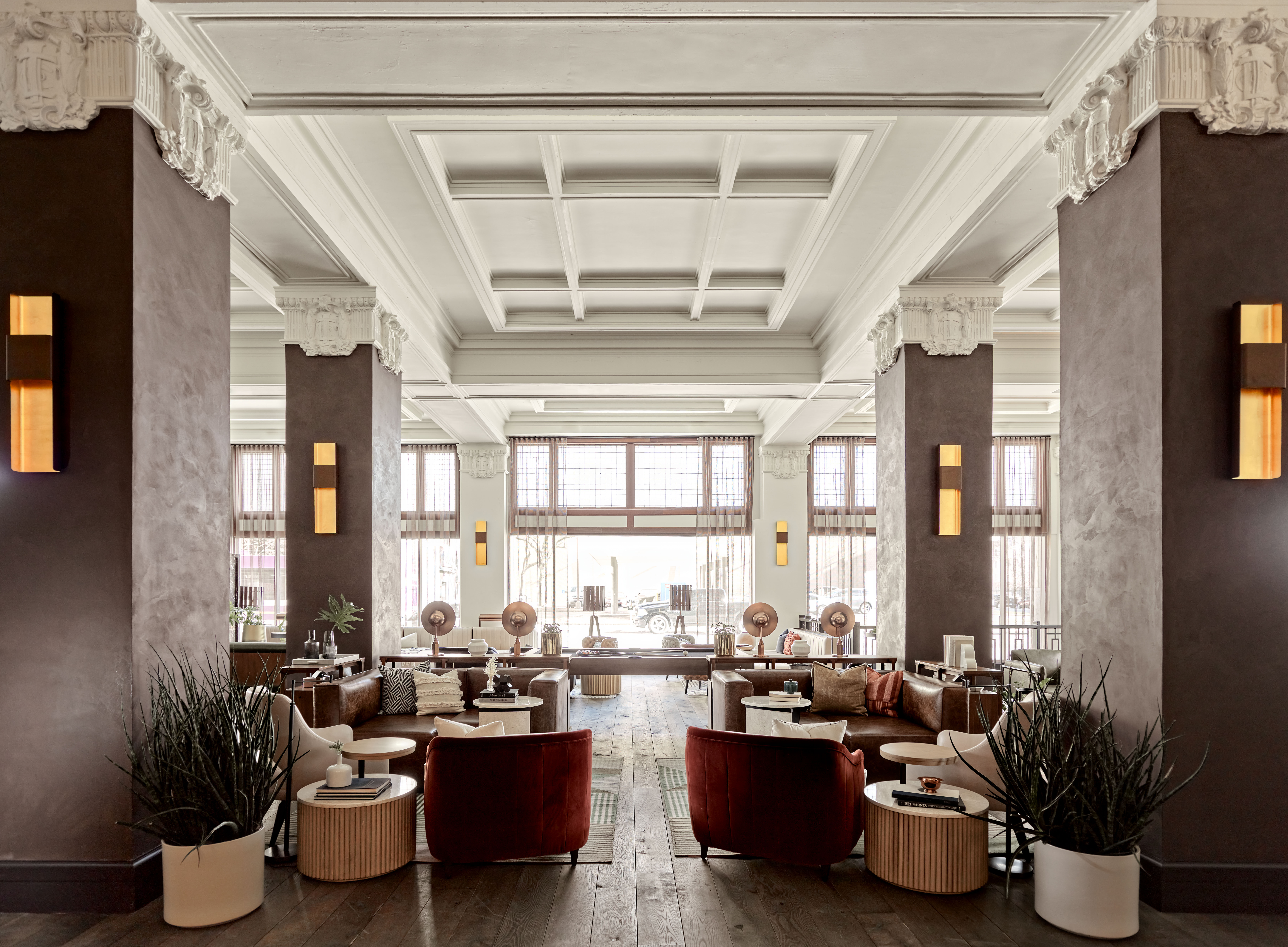 a lounge with upholstered seating under a white coffered ceiling and ornate plasterwork a lounge with upholstered seating under a white coffered ceiling and ornate plasterwork