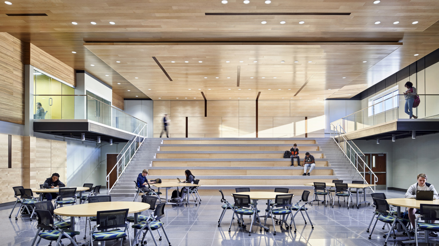 Learning staircase made from wood with ample lighting and learning pods on the side, dining area at the bottom at TCALC Learning staircase made from wood with ample lighting and learning pods on the side, dining area at the bottom at TCALC