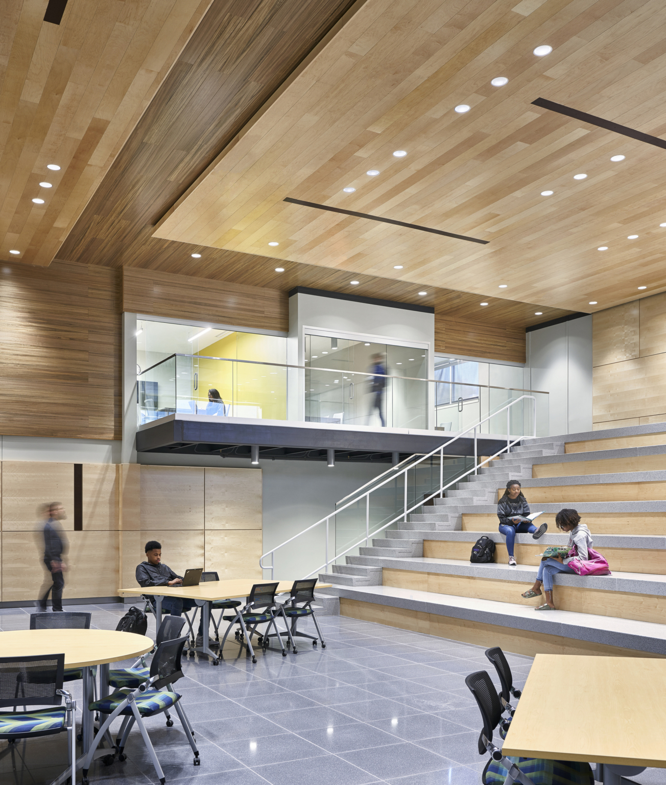 Open space with tables and wooden rows of seating at Topeka Center for Advanced Learning & Careers