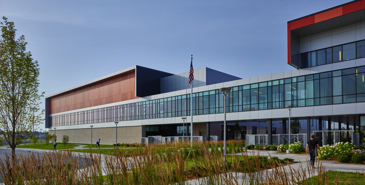 high school with glass and brick facade and native grass landscaping