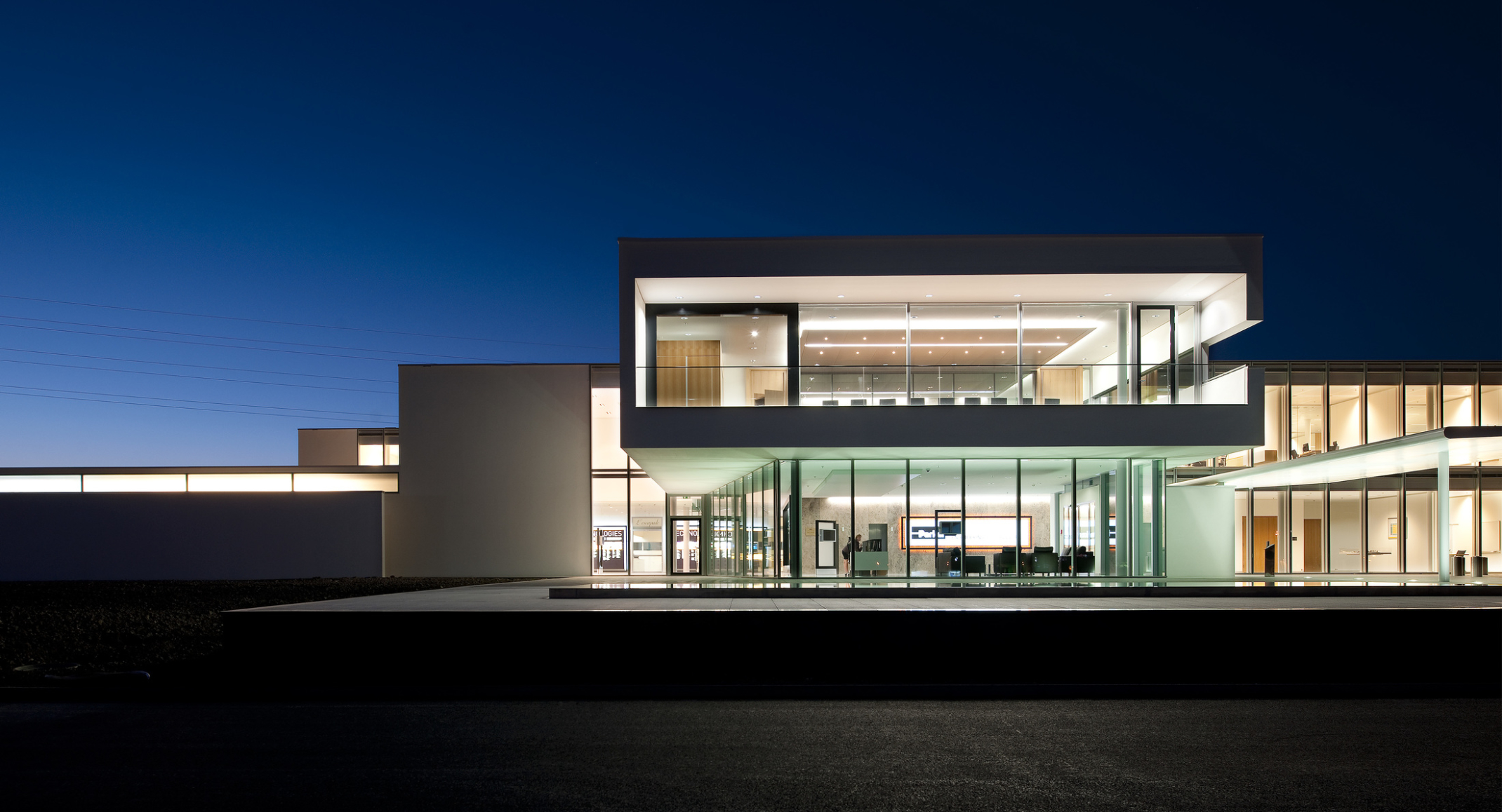 Nighttime exterior view of glass facade at Parker Hannifin European Headquarters.