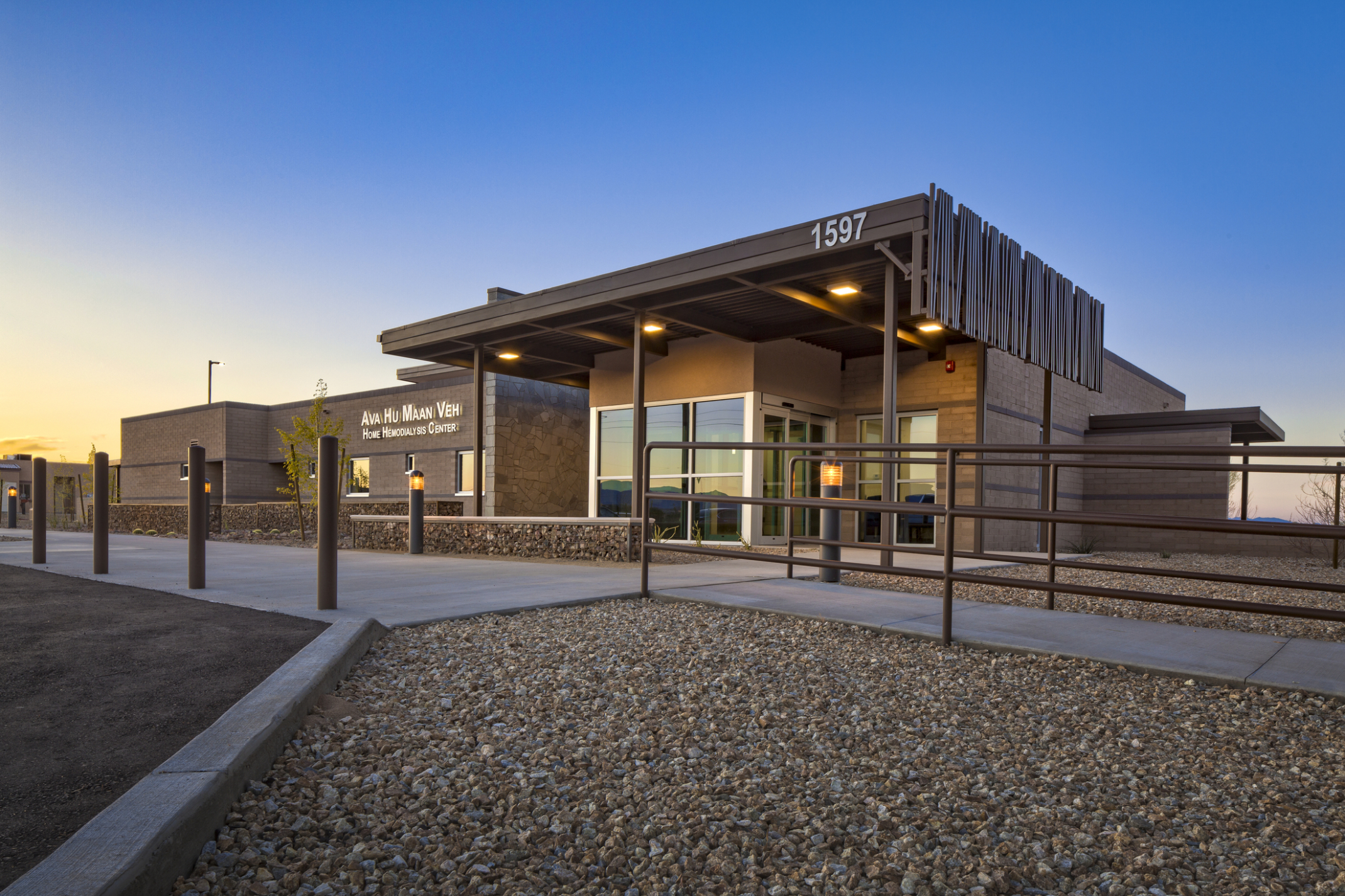 exterior of building at dusk with wood canopy entrance
