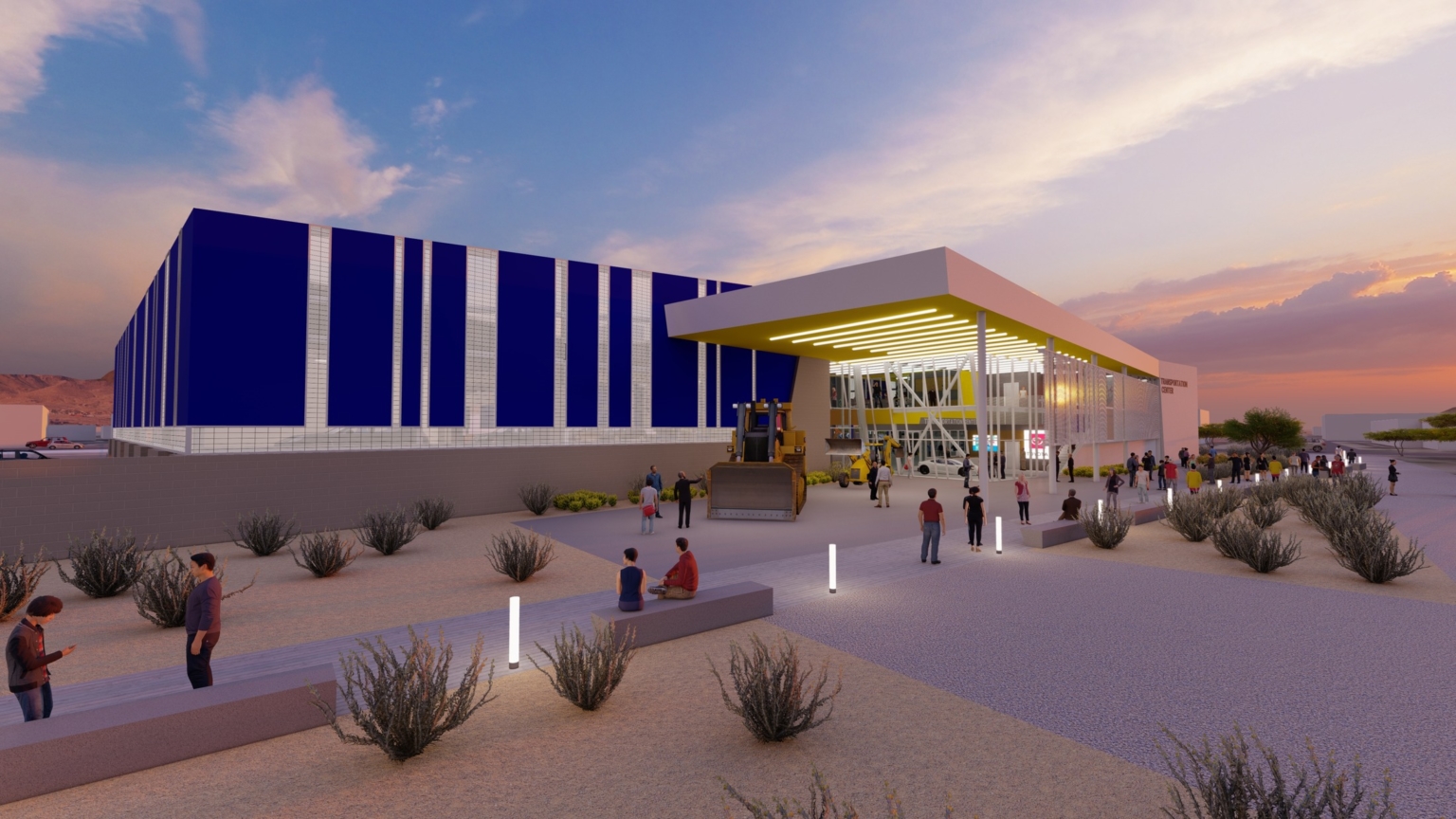 Dusk time at the school with light up walkways, benches, a blue facade on the building, and a lit-up overhang at Pima Community College Center of Excellence for Applied Technology.