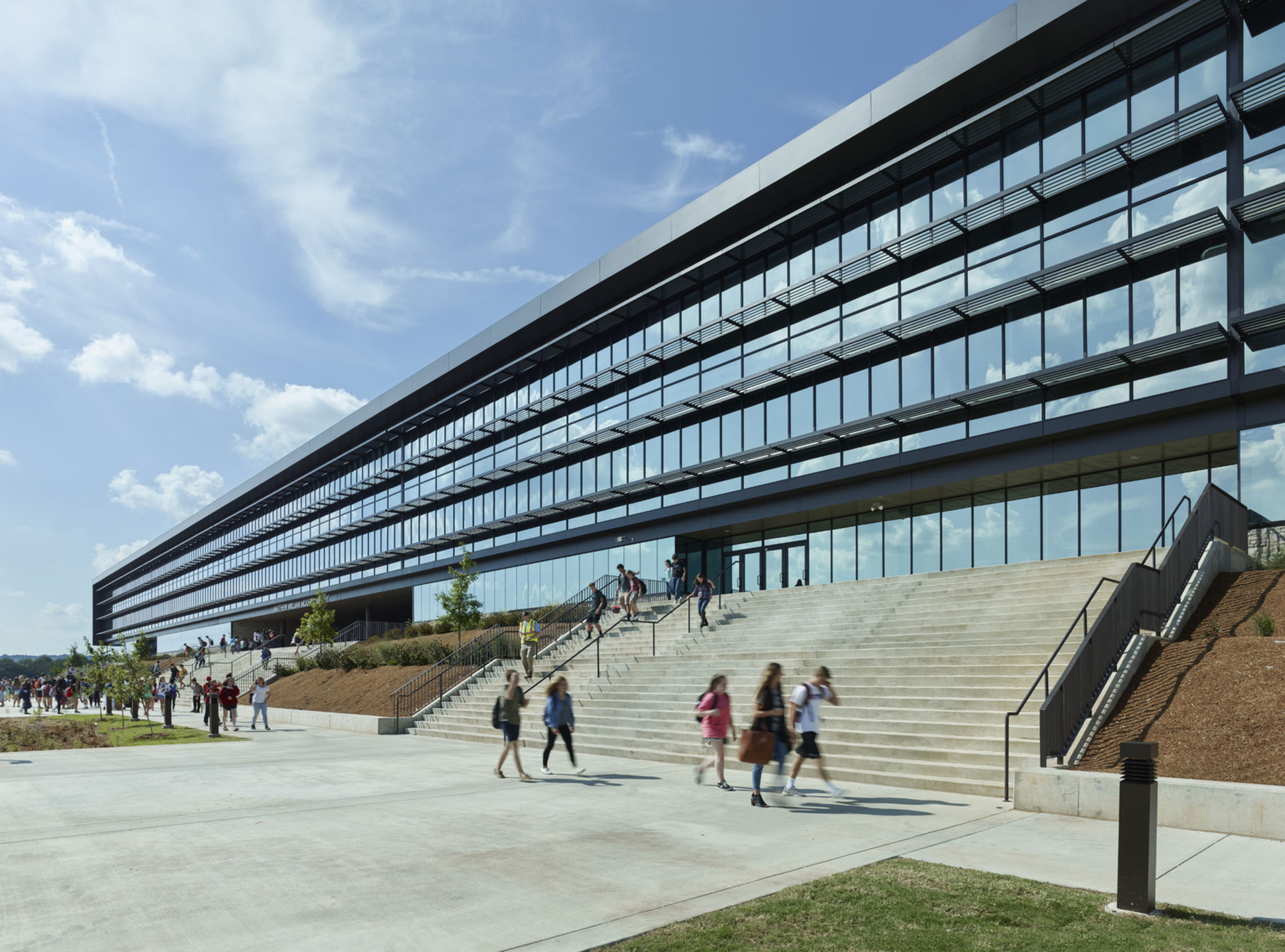 Staircase leading up to Fayetteville High School with wall of glass facade. Staircase leading up to Fayetteville High School with wall of glass facade.