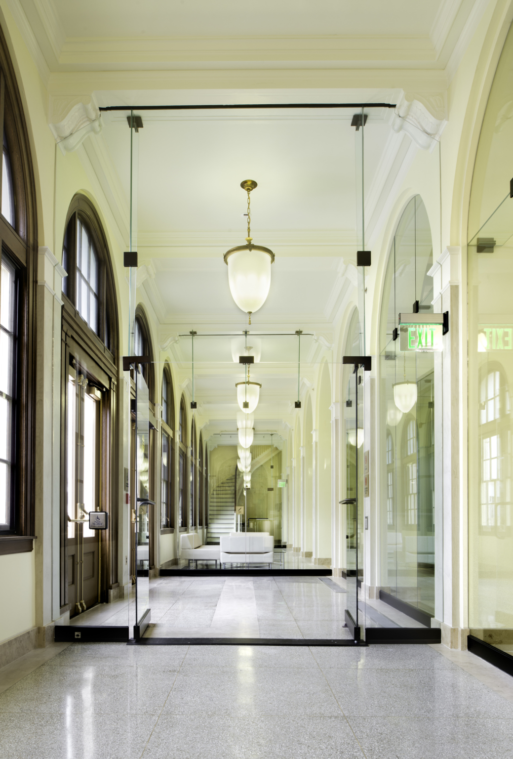 a mirrored hallway flanked by arched windows