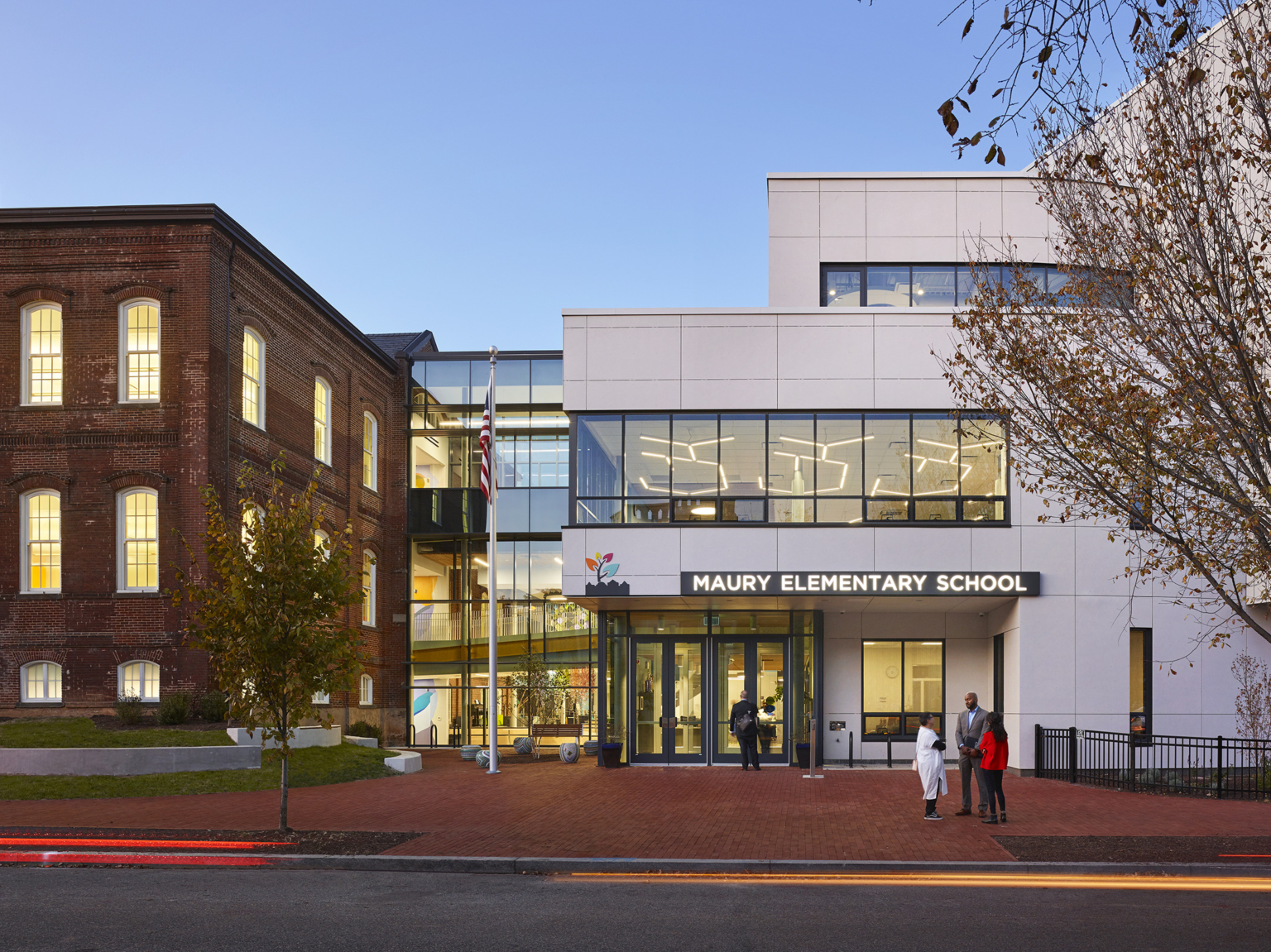 Evening view showing the glass connection of the historic 1886 school building and the new addition at Maury Elementary School.