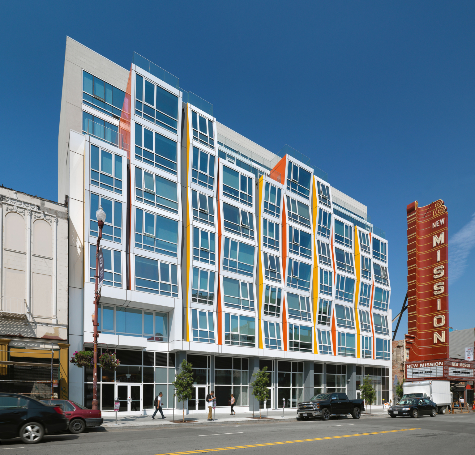 white and glass facade building with yellow and orange accents