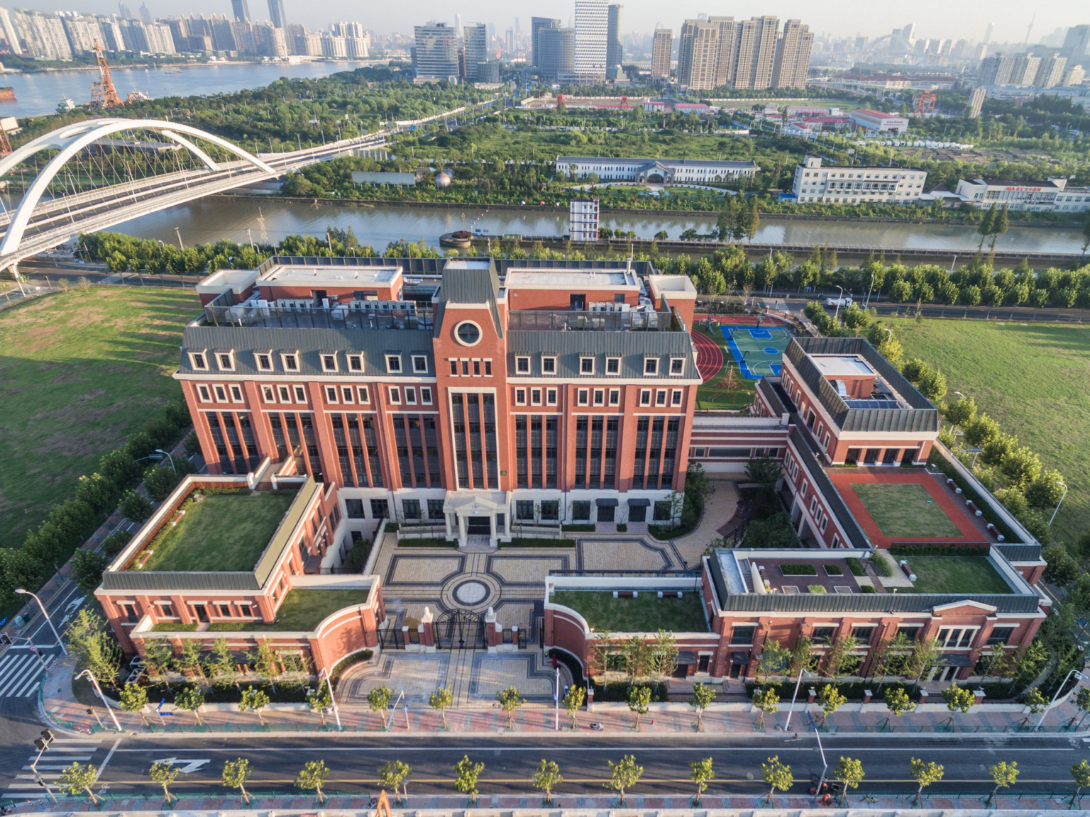 aerial view of Huili International School with city and bridge in background