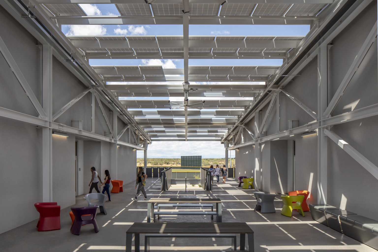 a shaded outdoor learning area with movable furniture and solar canopy shades