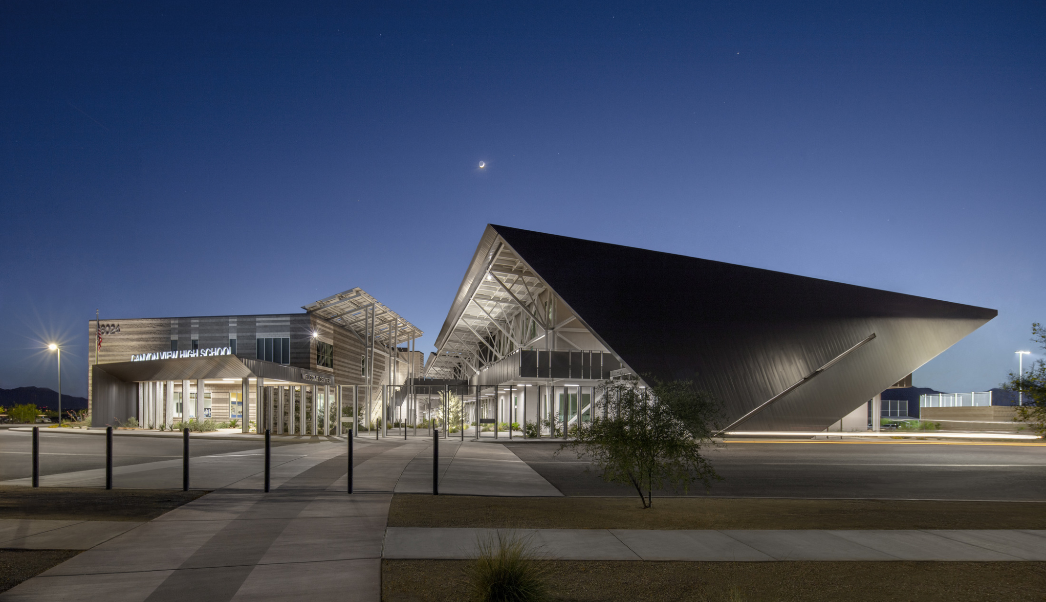 modern steel building with exposed structural beams and solar canopies illuminated at night modern steel building with exposed structural beams and solar canopies illuminated at night