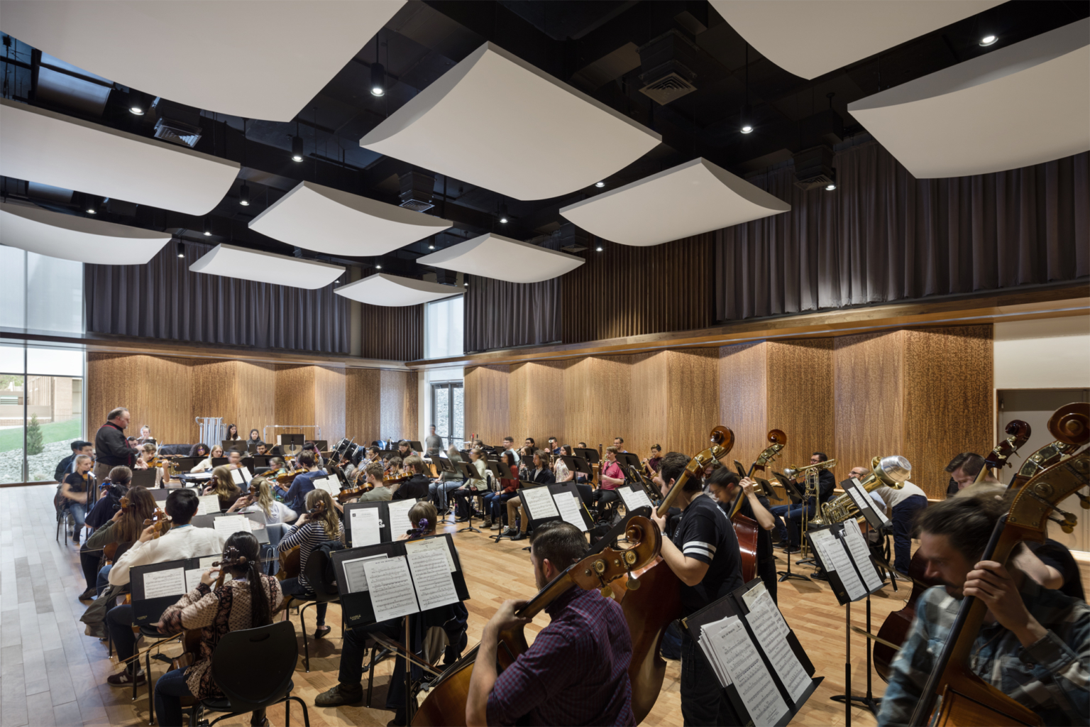 students practicing in rehearsal studio with wood angled sound panels on the walls and white acoustic sound panels on the ceiling at University of Nevada, Reno