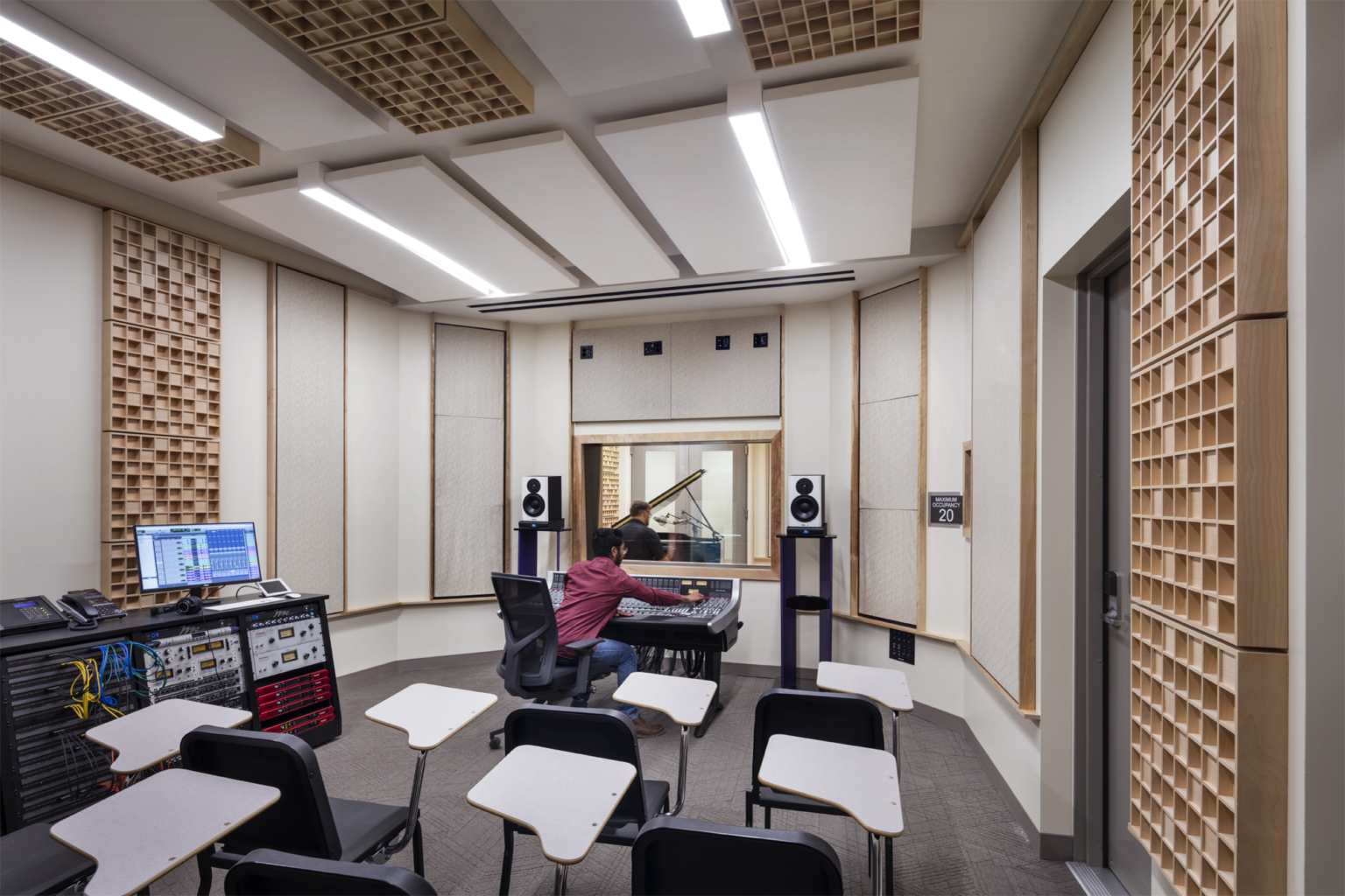 Recording studio with white walls, warm wood acoustic panels, and robust technology for learning at University of Nevada, Reno