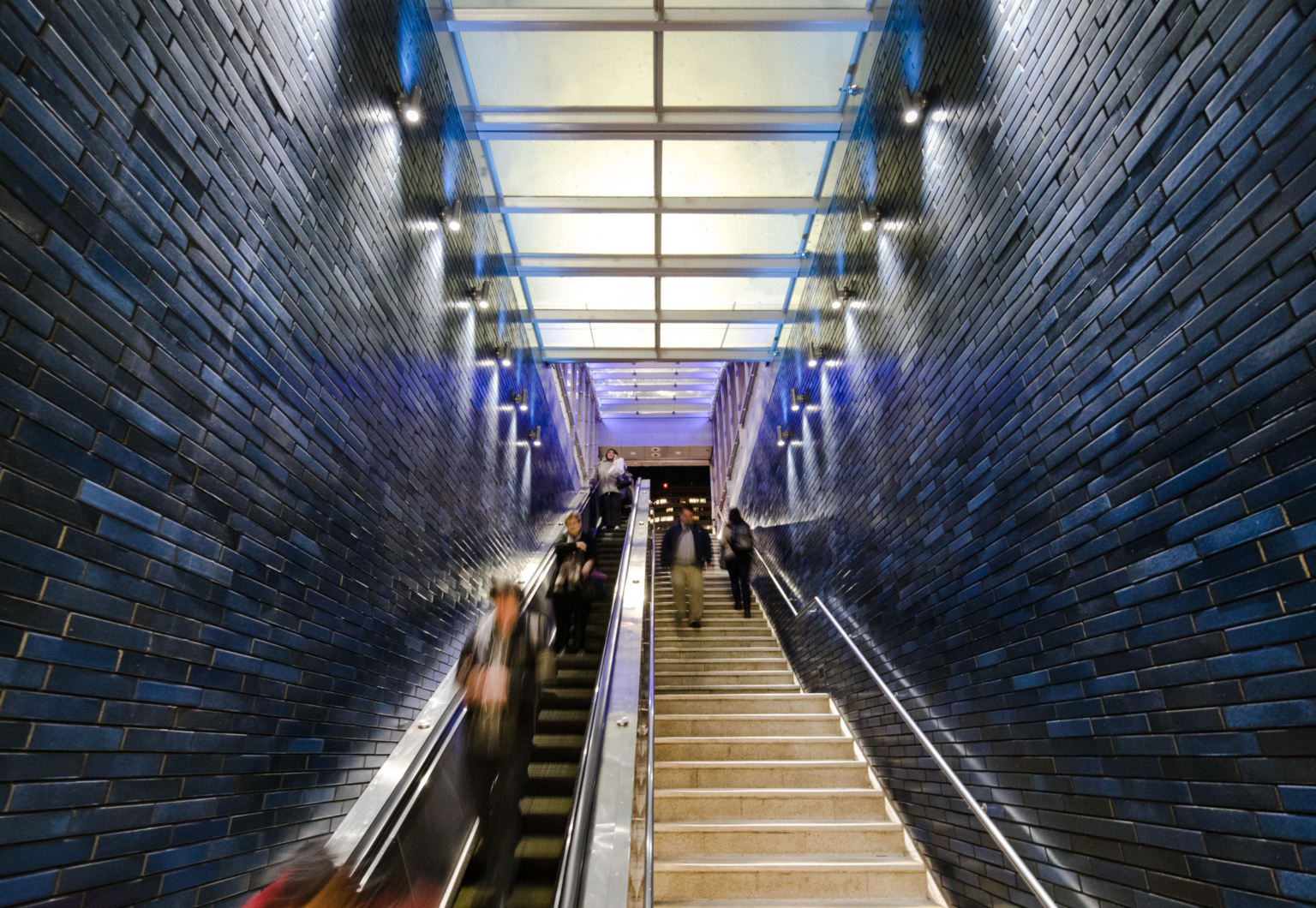 a glass canopy over a subterranean staircase with ceramic lined walls a glass canopy over a subterranean staircase with ceramic lined walls