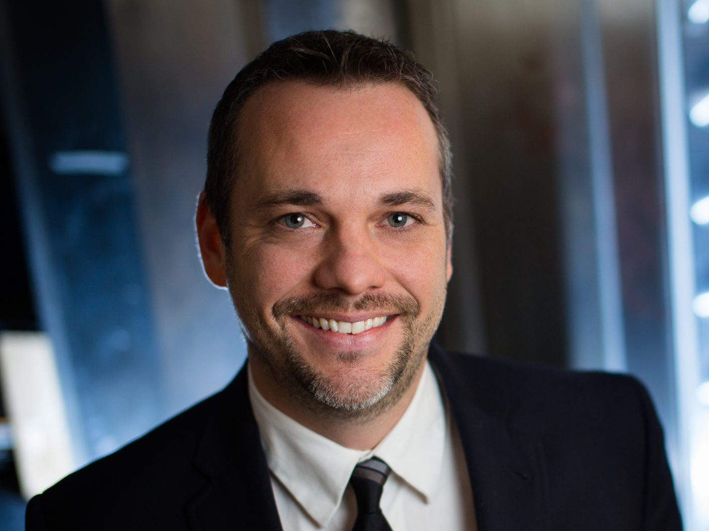 Todd Ferking in a dark suit and dark neck tie
