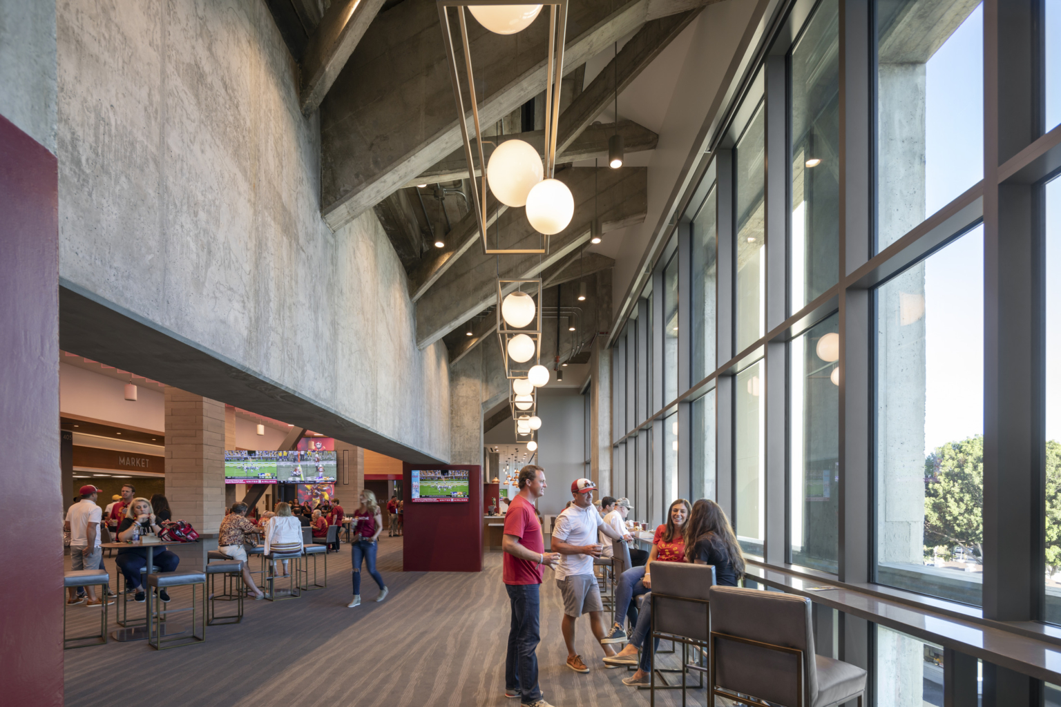 pendant lighting hanging between concrete bracing in front of floor to ceiling glass