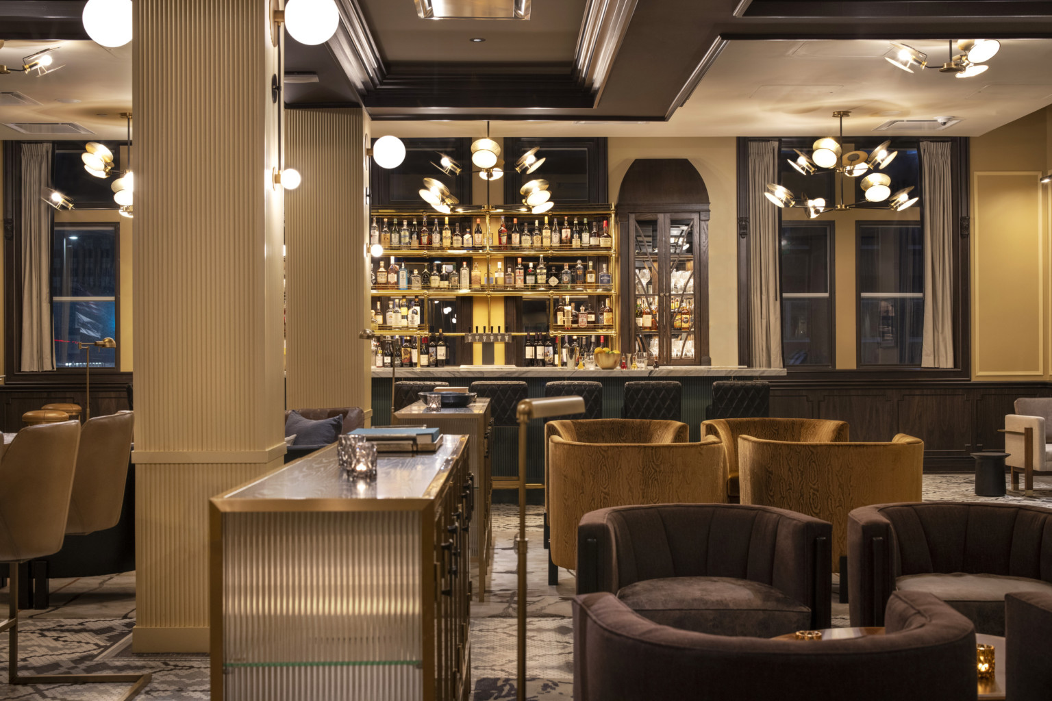 hotel lobby with velvet upholstered seating and an open bar