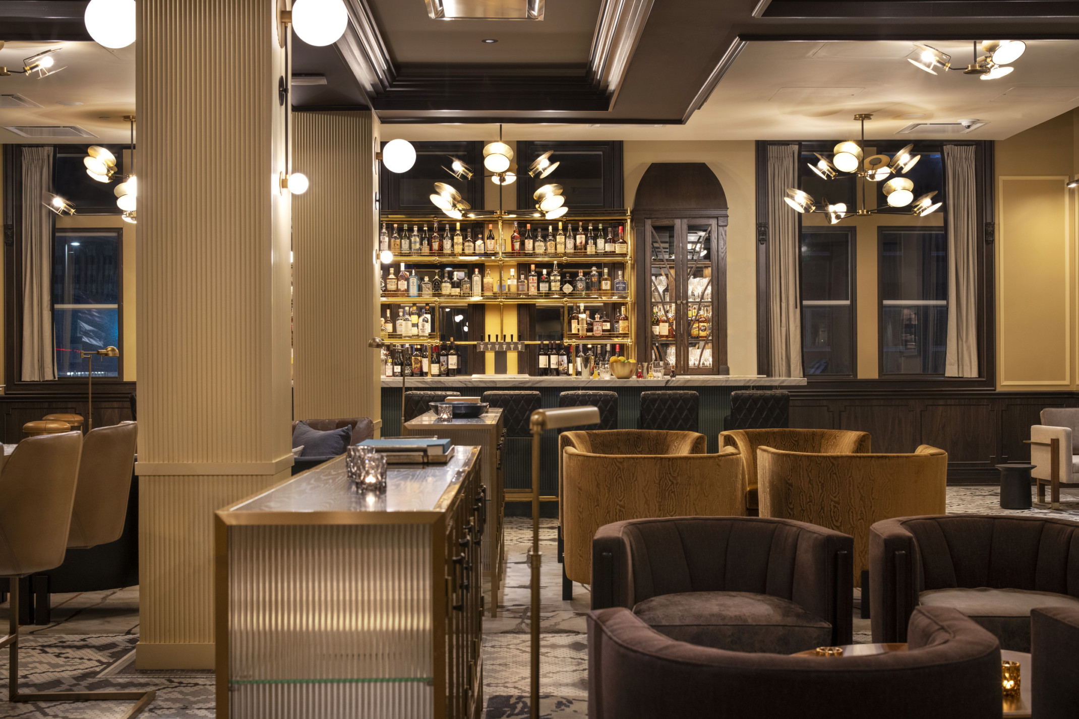 hotel lobby with velvet upholstered seating and an open bar
