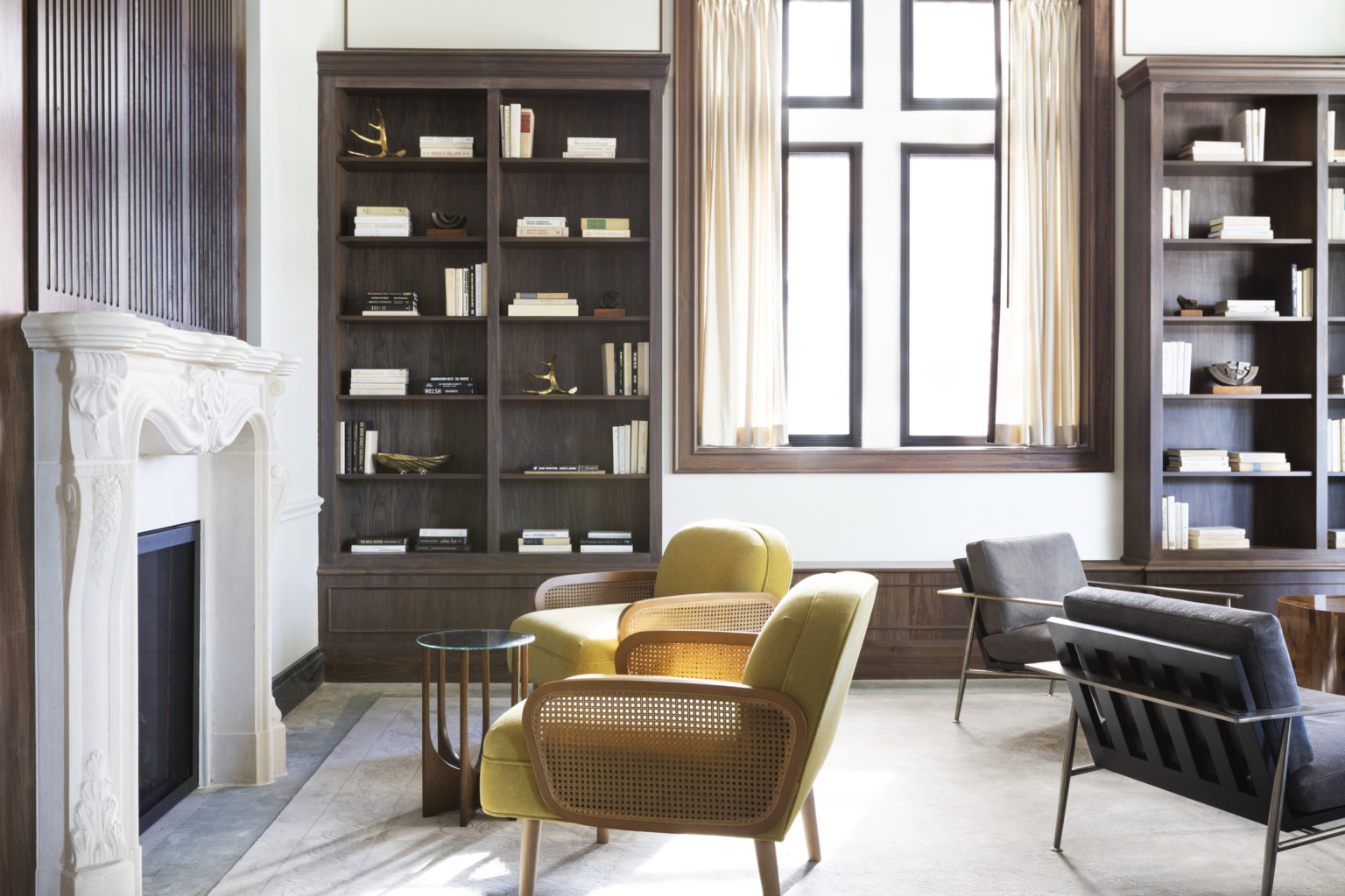 chartreuse and wicker cane chairs in front of a white fireplace and wooden bookcases chartreuse and wicker cane chairs in front of a white fireplace and wooden bookcases