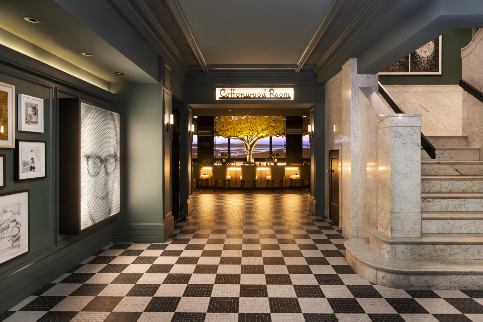 a marble staircase and gallery wall flank a black and white checkered floor a marble staircase and gallery wall flank a black and white checkered floor