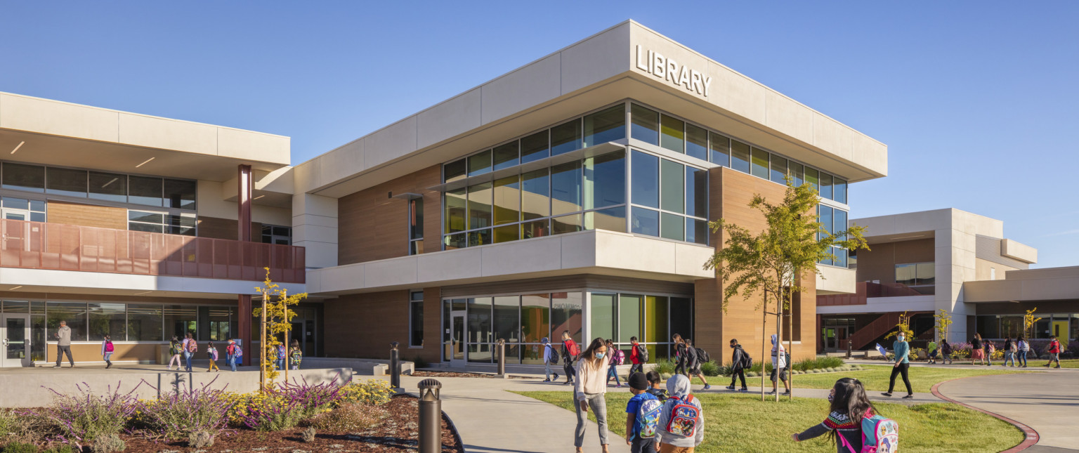 elementary kids walking in and out of school building