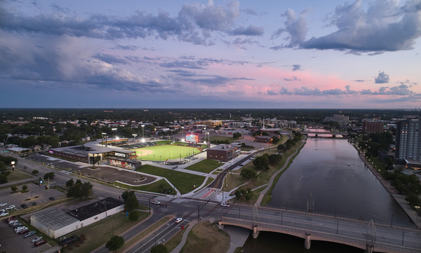 Aerial few looking at the lit baseball stadium at dusk with the Arkansas River on the right. Aerial few looking at the lit baseball stadium at dusk with the Arkansas River on the right.