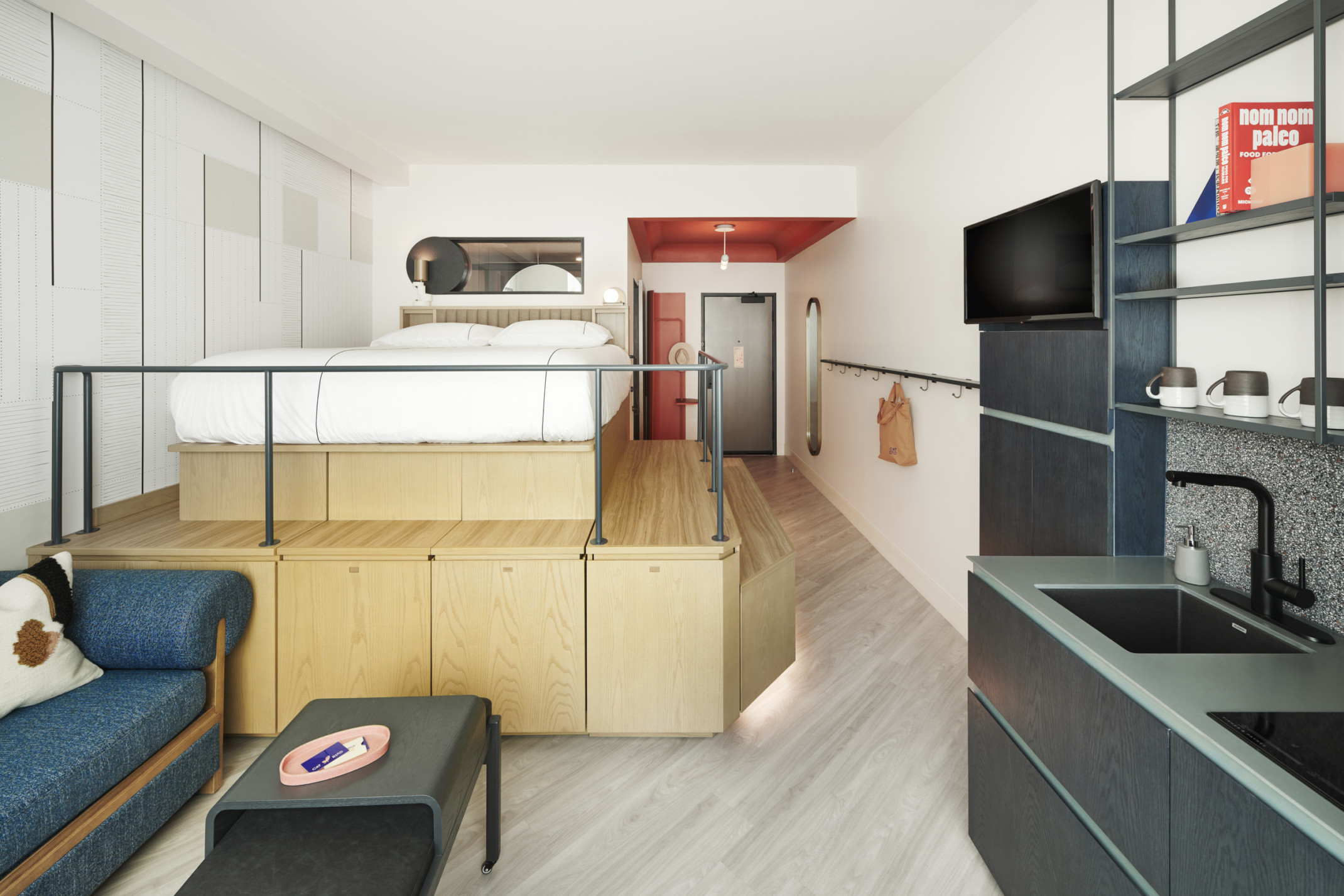 Guestroom with a raised platform bed and kitchenette at the Catbird Hotel Guestroom with a raised platform bed and kitchenette at the Catbird Hotel