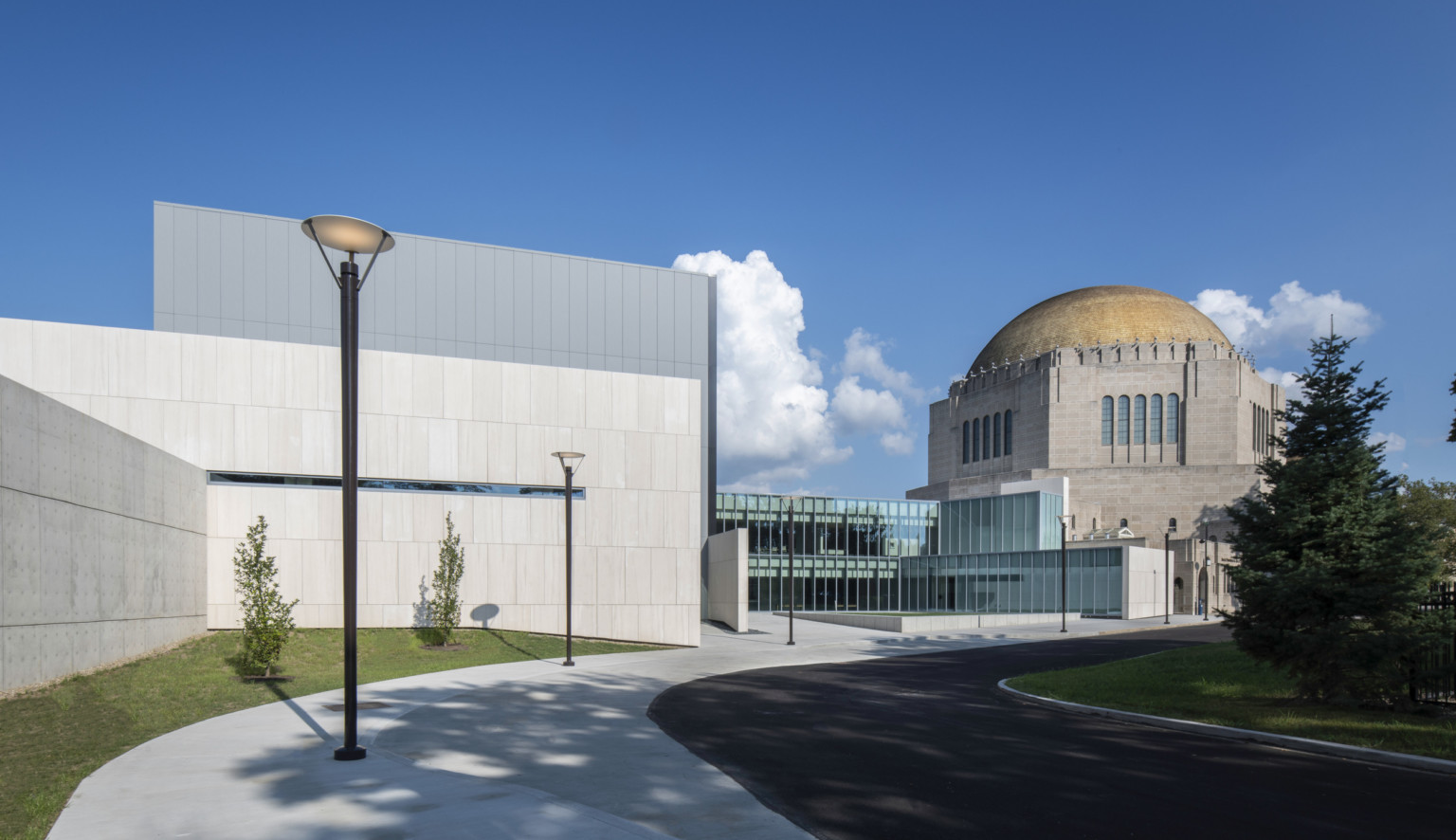 Concrete and glass addition of the new performing arts center meet the dome of the historic temple