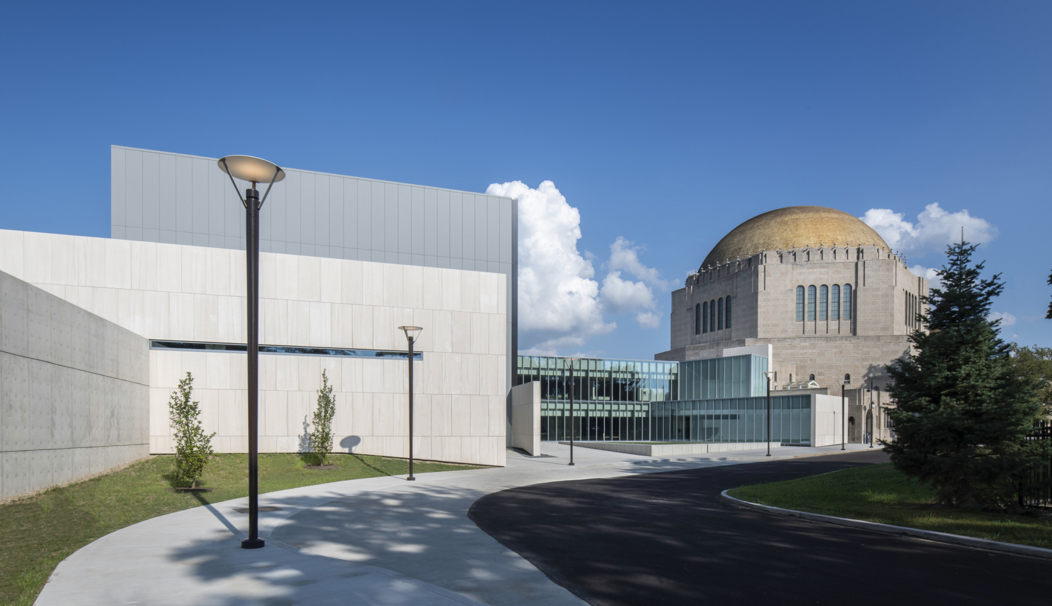 Concrete and glass addition of the new performing arts center meet the dome of the historic temple