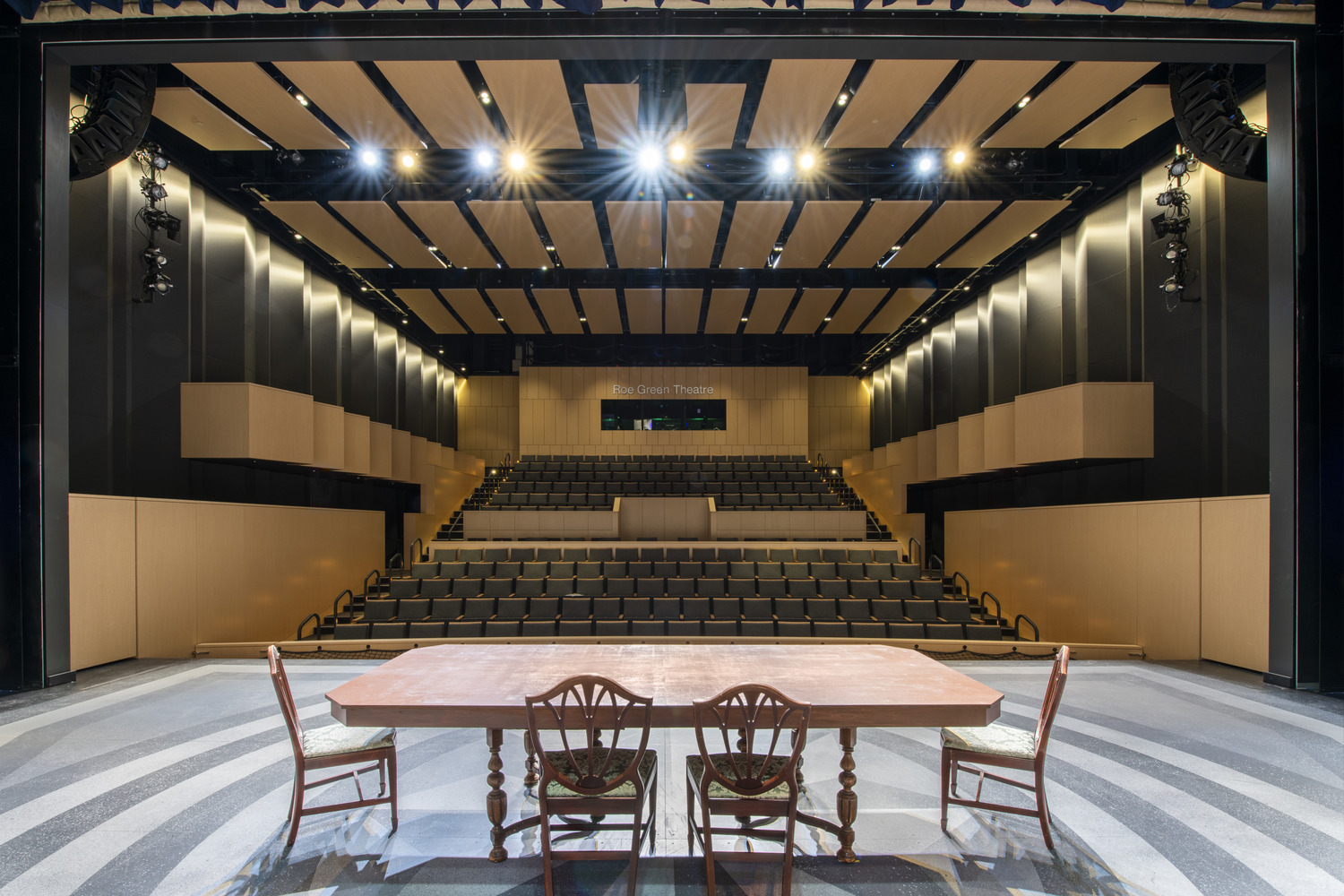 view of a theater with light wood and black fabric finishes from the stage view of a theater with light wood and black fabric finishes from the stage