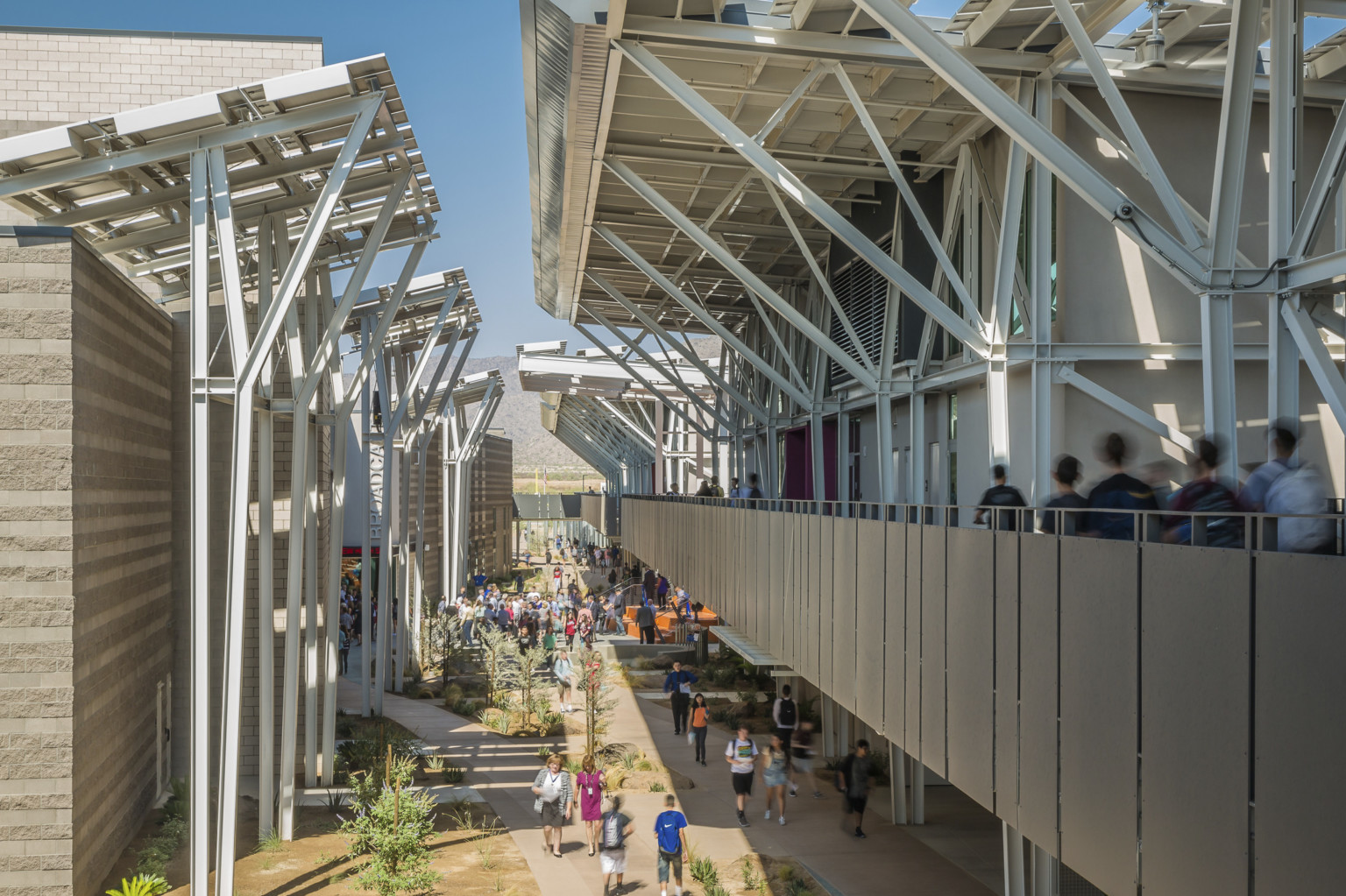 An elevated walkway through the center of an outdoor high school allows for daylighting and circulation An elevated walkway through the center of an outdoor high school allows for daylighting and circulation